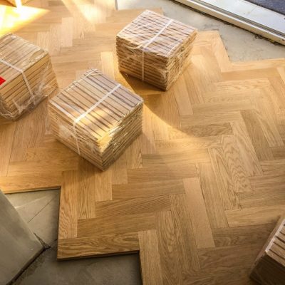 packs-of-wooden-parquet-flooring-are-seen-during-installation-of-wood-herringbone-kitchen-floor