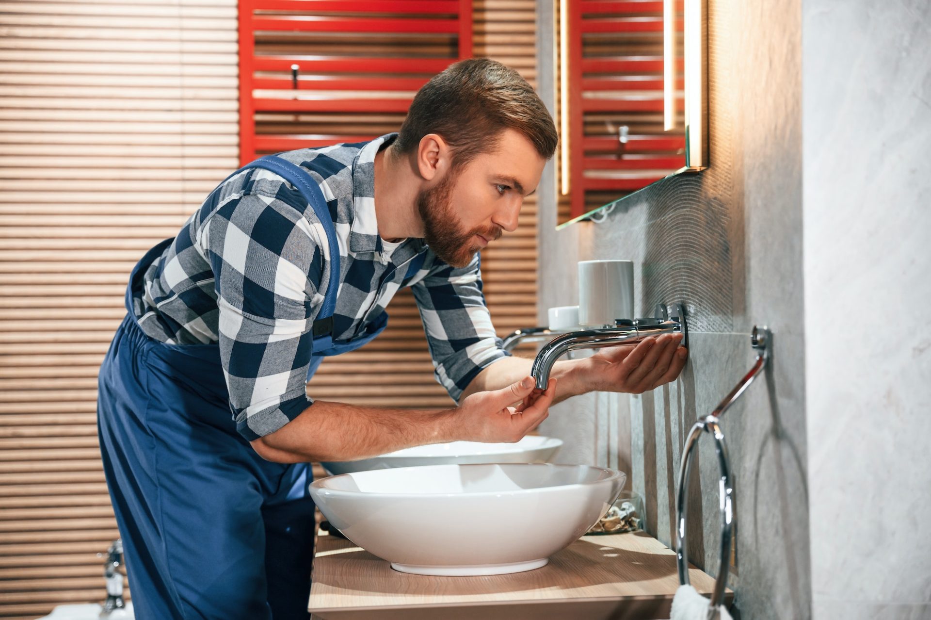 plumber-in-blue-uniform-is-at-work-in-the-bathroom-e1686029515618